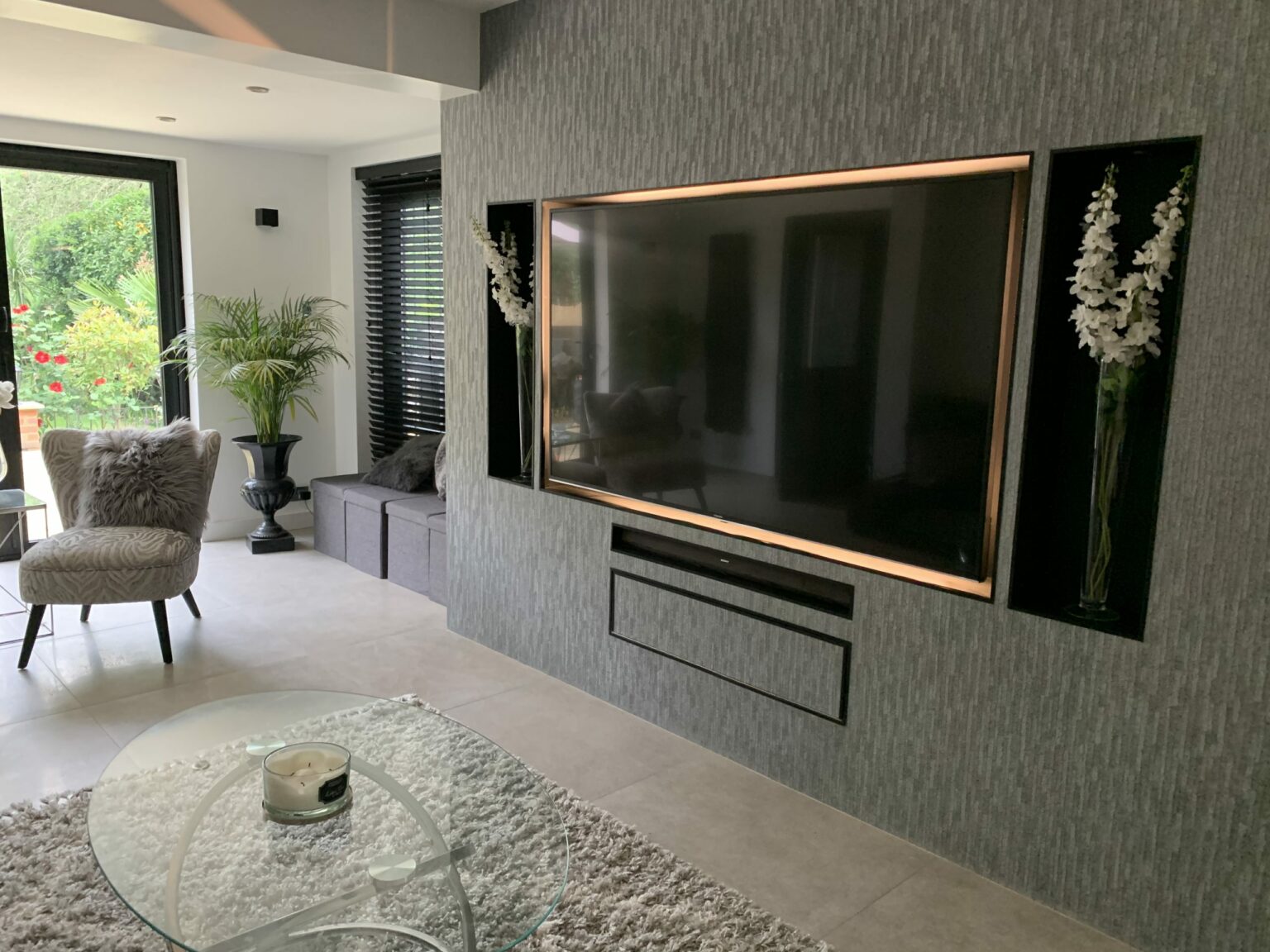 A stylish built-in TV unit housing a wall mounted TV, plants and entertainment boxes. Custom built for a client in Headstone, London.